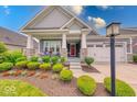 Inviting front porch with stone pillars, cozy seating, and a neatly landscaped garden at 5199 Green Valley Ln, Noblesville, IN 46062