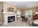 Cozy living room featuring a fireplace, neutral tones, and a view into other rooms through glass doors at 5538 N 700 W, McCordsville, IN 46055