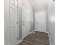 Bright hallway with wood-look floors leading to a white front door with glass insert at 5986 Regency Dr, Columbus, IN 47203