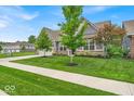 Charming home featuring a well-manicured lawn, beautiful landscaping, and a cozy covered entryway at 6536 Apperson Dr, Noblesville, IN 46060