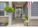 Inviting front porch with stylish decor and flowers, creating a warm and welcoming entrance to the home at 6536 Apperson Dr, Noblesville, IN 46060