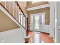 Bright foyer with hardwood floors, staircase, and a decorative glass front door at 705 Ridge Gate Dr, Brownsburg, IN 46112