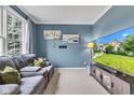 Comfortable living room features a cozy sectional sofa, blue walls, and a large TV at 705 Ridge Gate Dr, Brownsburg, IN 46112