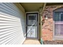 Close-up of the front door, showing the storm door, siding, brick and light fixture at 7150 Eagle Cove Dr, Indianapolis, IN 46254