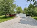 Exterior shot showcasing the home's detached garage and gravel driveway at 725 N State Road 75, Lebanon, IN 46052