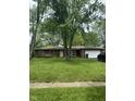 Charming brick home featuring an attached garage and a well-maintained front yard with mature trees at 8312 Lamira Ln, Indianapolis, IN 46234