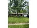 Charming brick home featuring an attached garage and a well-maintained front yard with mature trees at 8312 Lamira Ln, Indianapolis, IN 46234