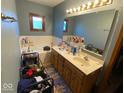 Bathroom featuring a tub, double sink vanity, and a classic wood frame window at 902 St Andrews Dr, Avon, IN 46123
