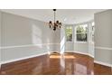 Bright dining room with bay window, chandelier, hardwood floors, and neutral paint at 9055 Glass Chimney Ln, Fishers, IN 46037