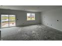 Spacious living room with a large window overlooking a pond and sliding glass door access to the backyard at 9125 Steinbeck Ln, Indianapolis, IN 46239