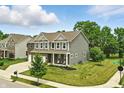 Charming two-story home with a manicured lawn, showcasing its appealing curb appeal on a sunny day at 10113 Gallop Ln, Fishers, IN 46040