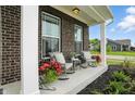 Inviting front porch with comfortable rocking chairs, potted plants, and decorative pillows at 10113 Gallop Ln, Fishers, IN 46040