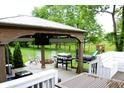 Covered outdoor kitchen and seating area, complete with grill, TV, firepit, and space for entertaining at 10113 Gallop Ln, Fishers, IN 46040