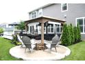 Backyard patio with a stone firepit, chairs, outdoor furniture, and well-maintained landscaping at 10113 Gallop Ln, Fortville, IN 46040