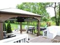 Outdoor area featuring an entertainment space with a grill, stone firepit, and playground in the background at 10113 Gallop Ln, Fortville, IN 46040