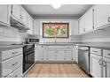 Well-lit kitchen featuring white cabinets, stainless steel appliances, granite countertops, and wood-look flooring at 110 Leichester Ct, Noblesville, IN 46060