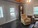 Comfortable living room with hardwood floors, a large window, and an antique grandfather clock at 121 N Main St, Pendleton, IN 46064
