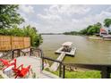 Lake view from a deck with red chairs and a railing at 121 Wesley Cir, Noblesville, IN 46062