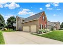 View of the side of the home featuring a large driveway, and two-car garage at 13191 Roma, Carmel, IN 46074