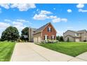 View of the home featuring a large driveway, lush grass and a basketball hoop at 13191 Roma, Carmel, IN 46074