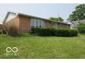 Exterior view of a brick home with green lawn and mature bushes at 1333 S B St, Elwood, IN 46036