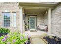 Inviting front porch with a comfortable bench, decorative flowers, and a 'Welcome' door sign at 16095 Tenor Way, Noblesville, IN 46060