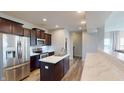 This is a modern kitchen featuring stainless steel appliances, a central island, and dark wood cabinetry at 16551 Branham Dr, Fishers, IN 46040