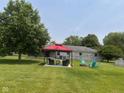 Expansive backyard featuring a covered patio, fire pit with chairs, and above ground swimming pool at 2213 Holden Dr, Anderson, IN 46012