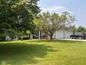 Attractive brick home featuring a manicured lawn, mature trees, and an attached two-car garage at 2213 Holden Dr, Anderson, IN 46012