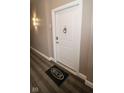 Entryway to apartment 211 with a white door, black rug with Hudson logo and a modern sconce on the grey wall at 355 E Ohio St # 211, Indianapolis, IN 46204