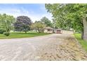 Attractive ranch home with a long gravel driveway and a lush front lawn under a bright sky at 4010 S Bazil Ave, Indianapolis, IN 46239