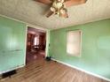 Inviting living room featuring green walls, wood-like flooring, and a ceiling fan at 408 W 4Th St, Anderson, IN 46016