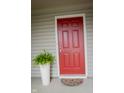 Stylish red front door complemented by a potted fern, enhancing curb appeal at 4114 Dunedin Ct, Noblesville, IN 46062