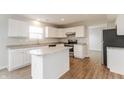 Modern kitchen with white cabinets, granite countertops, and stainless steel appliances at 413 Youngs Creek Ct, Franklin, IN 46131