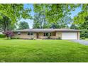 Charming single-story home with an attached garage, well-maintained lawn, and mature landscaping at 5205 Staughton Dr, Indianapolis, IN 46226
