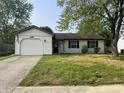 Charming one-story home with a well-kept lawn, attached garage, and an American flag waving at 5331 Yucatan Dr, Indianapolis, IN 46237