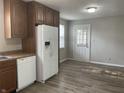 Bright kitchen featuring wooden cabinets, white appliances, laminate countertop, and a white door leading outside at 5331 Yucatan Dr, Indianapolis, IN 46237