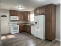 Well-lit kitchen with wooden cabinets, white appliances, laminate countertop, and a white door leading outside at 5331 Yucatan Dr, Indianapolis, IN 46237