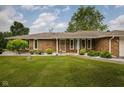 Lovely brick home displaying manicured landscaping with decorative stone and verdant shrubbery in the front yard at 5749 Teresa Dr, Alexandria, IN 46001