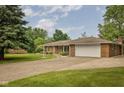This brick home offers an attached garage, manicured lawn, and beautiful landscaping, creating curb appeal at 5749 Teresa Dr, Alexandria, IN 46001