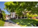 Beautiful home exterior with large tree, well-manicured lawn, and covered front porch at 5760 Central N Ave, Indianapolis, IN 46220