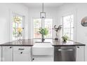 Bright kitchen featuring a farmhouse sink, stainless steel dishwasher, and decorative stained glass windows at 5946 Guilford Ave, Indianapolis, IN 46220