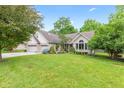 Lush front lawn frames this charming brick home with attached garage and mature trees at 6980 White Oak Dr, Avon, IN 46123