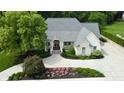 Beautifully landscaped front exterior with a circular driveway and lush, mature trees at 7106 Royal Oakland Dr, Indianapolis, IN 46236