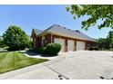 Three-car garage with brick exterior and ample parking space, complemented by a well-manicured lawn at 7413 Misty Woods Ln, Indianapolis, IN 46237
