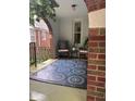 Cozy covered porch with seating area, plants, and a stylish patterned rug creating a relaxing outdoor space at 828 N Butler Ave, Indianapolis, IN 46219