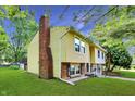 Split-level home featuring siding, chimney, and landscaped yard at 8920 Caminito Rd, Indianapolis, IN 46234