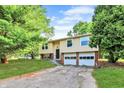 Split-level home featuring a two-car garage, siding, and landscaped front yard at 8920 Caminito Rd, Indianapolis, IN 46234