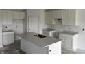 Unfinished kitchen featuring white cabinetry, grey countertops, and a kitchen island with a double sink at 9137 Steinbeck Ln, Indianapolis, IN 46239