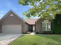 Charming brick home featuring a well-manicured lawn and a two-car garage at 9302 N Bayland Dr, McCordsville, IN 46055